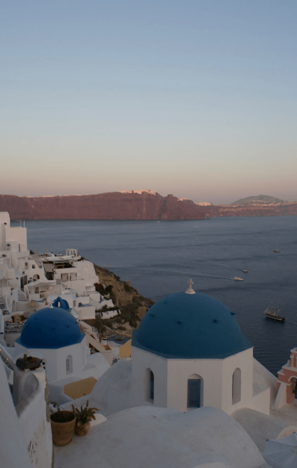 White buildings with blue domes overlooking the Aegean Sea in Santorini